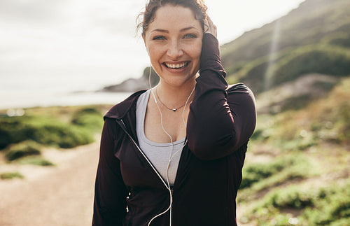 Cheerful female runner standing outdoors