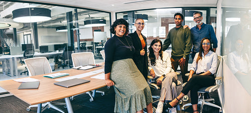 Team of businesspeople smiling at the camera in a boardroom