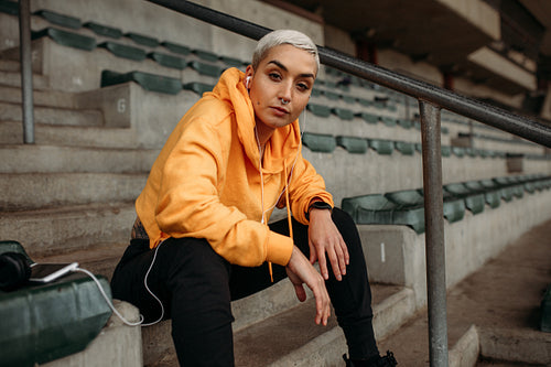 Woman athlete relaxing sitting in the stands of a stadium