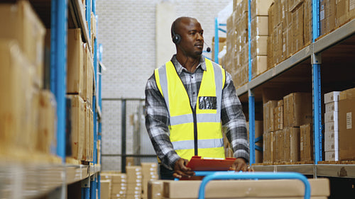 Order fulfilment and voice directed warehousing: Voice picker locates and collects boxes for shipping