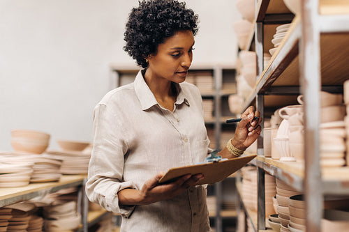 Ceramic shop owner taking stock in her store