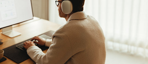 Focused man working on computer in small office