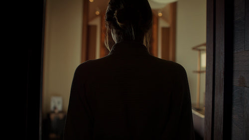 Woman in a bathrobe entering a luxurious spa room for a relaxing massage treatment