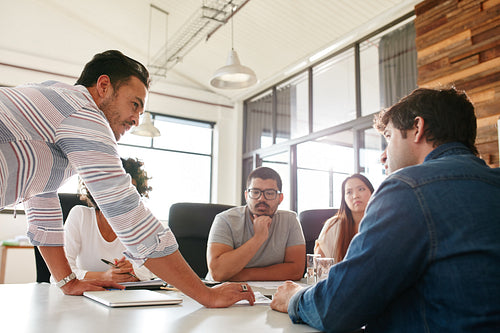 Businessman leading meeting at boardroom table