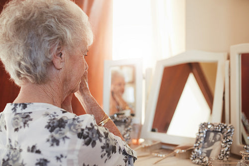 Senior woman getting ready at dresser