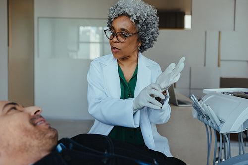 Dentist prepares male patient for exam at modern dental clinic
