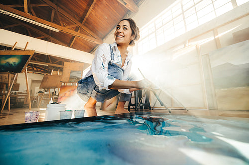 Imaginative female painter smiling and looking away