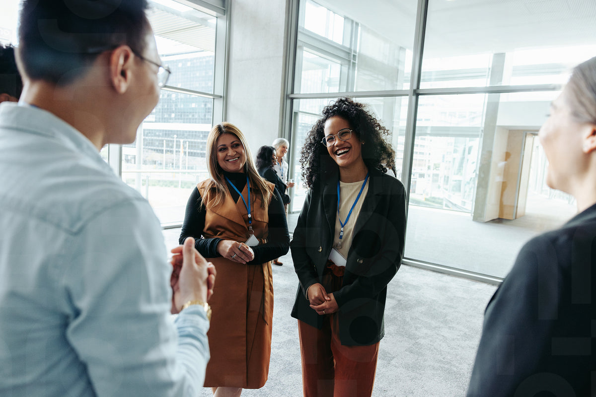 Colleagues networking at a corporate event in a modern office building ...