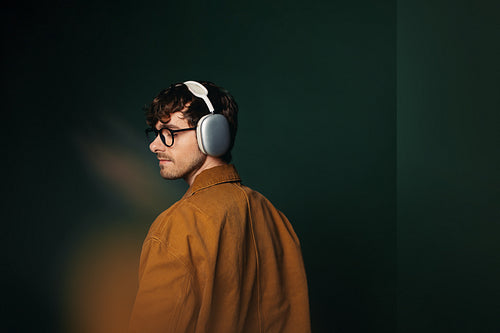 Young man looks aside in headphones for a relaxed studio portrait