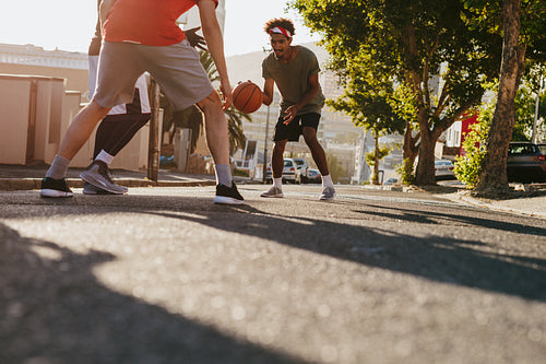 Men playing basketball on street