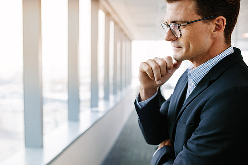 Businessman standing in office and thinking
