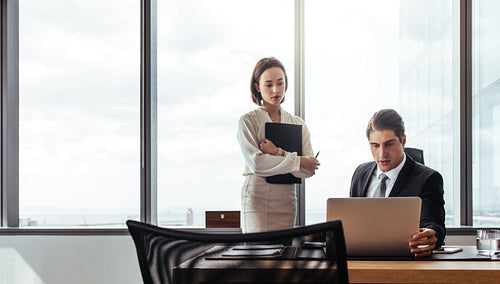 Two business people looking at laptop