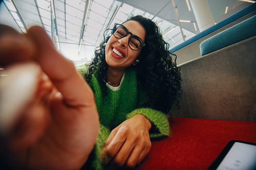 Cheerful woman using stylus on tablet in indoor setting