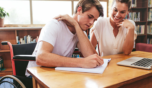 Disabled student studying with his tutor