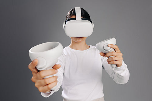 Woman gaming with vr goggles and game controllers