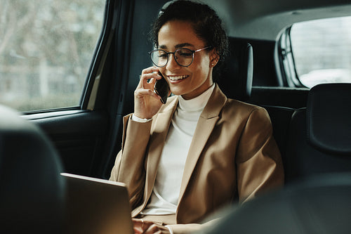 Businesswoman working inside a cab on the way to work