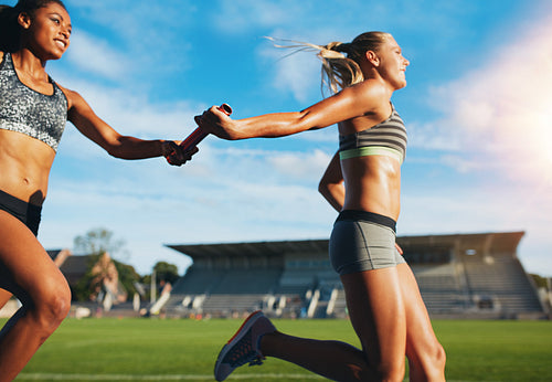 Female relay team passing the baton