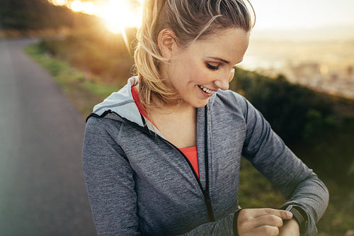 Female runner adjusting her wrist watch