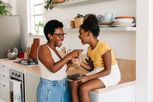 Mom and daughter sharing moments of laughter in the kitchen