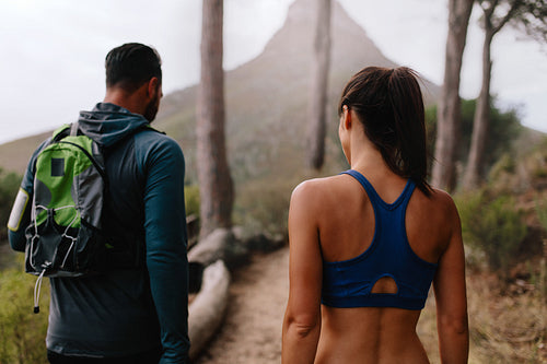 Healthy young couple walk through mountain trail