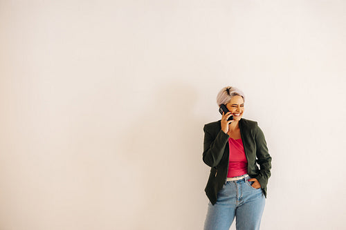 Cheerful young businesswoman taking a phone call in an office