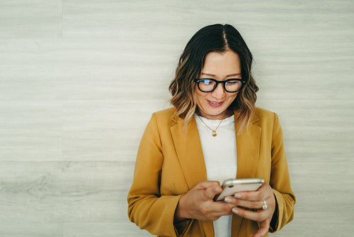 Happy female entrepreneur reading a text message in an office
