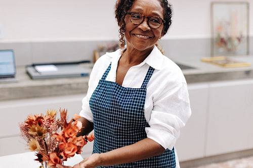 Woman arranging a bouquet of flowers for her small business