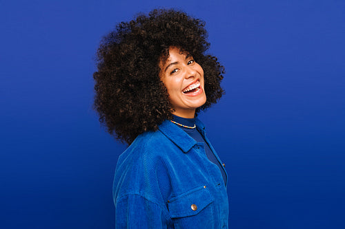 Beautiful woman laughing happily against a blue background
