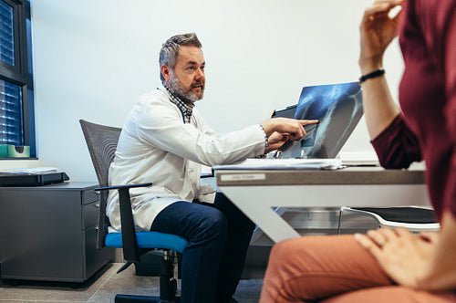 Medical doctor explaining x-ray result to patient