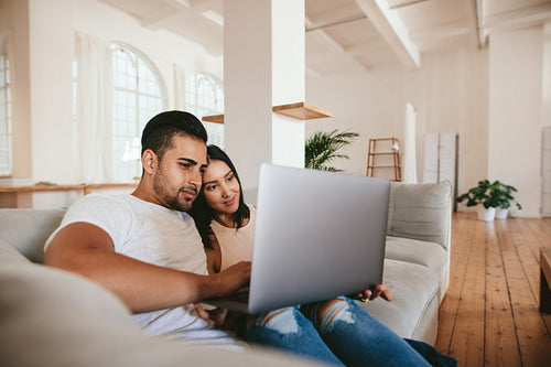 Loving young couple using laptop at home