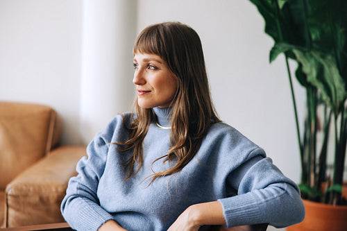 Young businesswoman looking away thoughtfully in a modern office