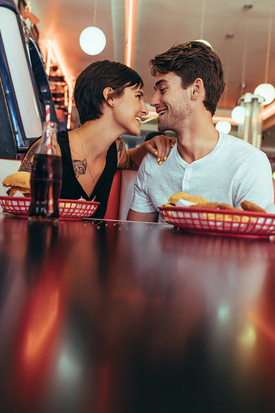Happy couple sharing a french fry at a restaurant