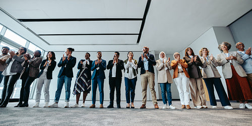 Diverse group of business people clapping at a seminar in a modern workshop