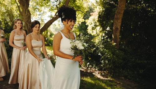 Joyful bride and bridesmaids enjoying a sunny wedding day outdoors