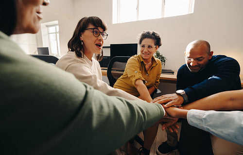 Team meeting with unified hands displaying collaboration and success