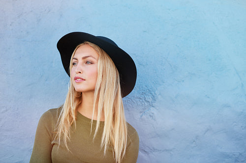 Attractive young female model with hat looking away