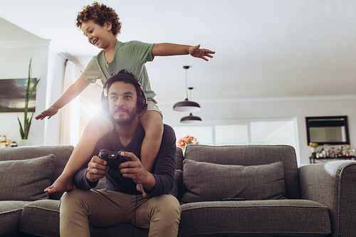 Father and son playing video game at home