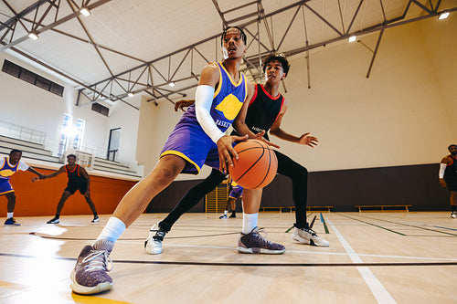 Basketball game with players competing for ball possession on an indoor court