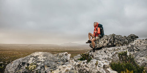 Woman hiker sitting on a hill relaxing