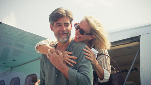 Happy mature couple embraces warmly after arriving by seaplane for a luxurious vacation