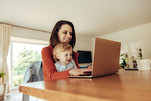 Woman with baby working on laptop