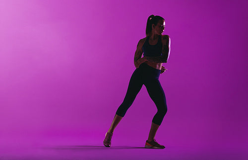 Fitness woman working out on purple background