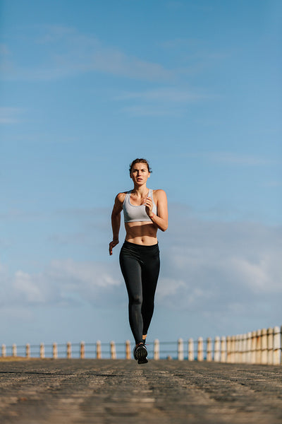 Fitness woman running on the seaside promenade