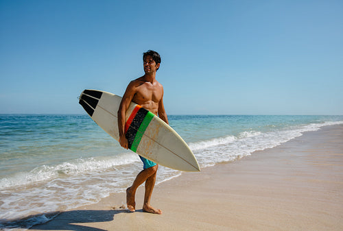 Man with surf board on beach