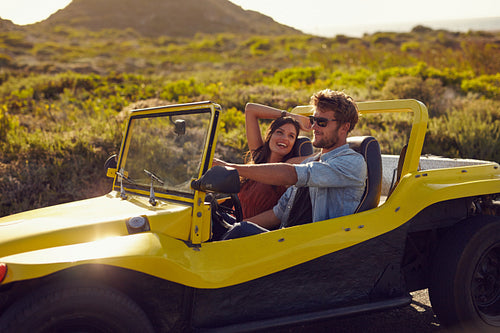 Happy young couple on a road trip in beach buggy