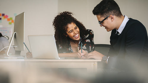 Businesswoman laughing during a discussion with colleague at work