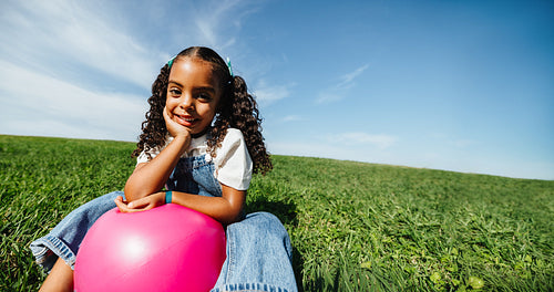 Girl enjoying playful summer moment in grassy field