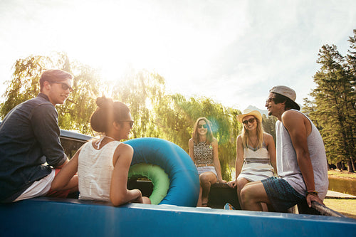 Group of young friends sitting in the back of a pickup