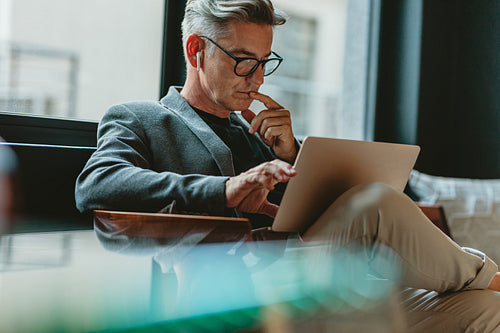 Businessman reading emails in office lobby