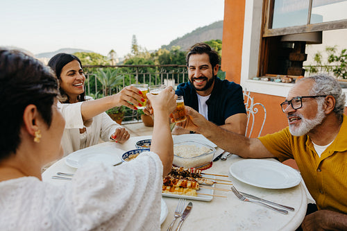 Family enjoying a barbecue and drinks outside on a sunny day